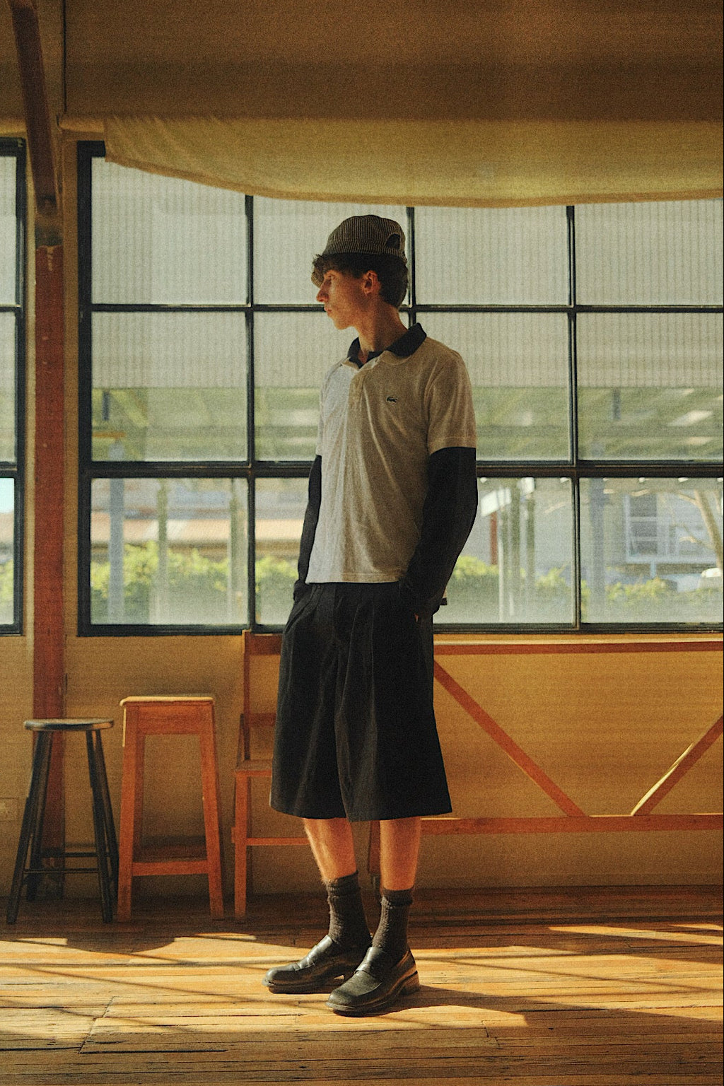 Connor wearing the College Pleated Shorts in a natural light studio